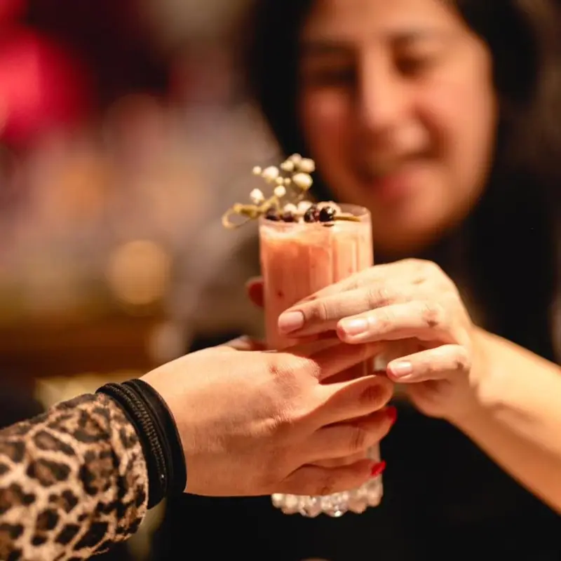 Cóctel rosado y cremoso pasando de mano en mano