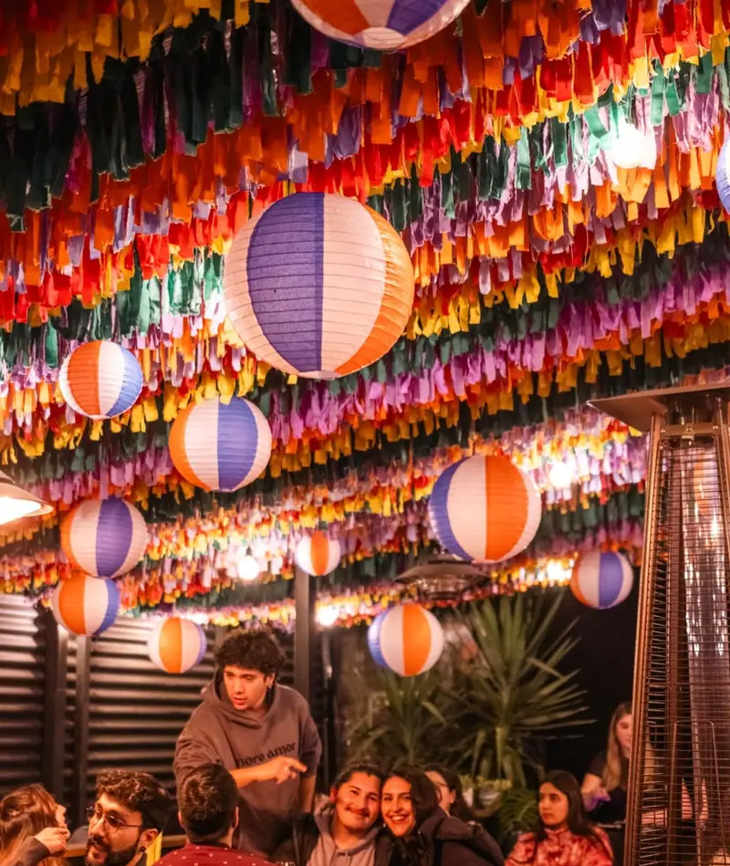 Salón decorado con papel picado y faroles de colores para la fondita